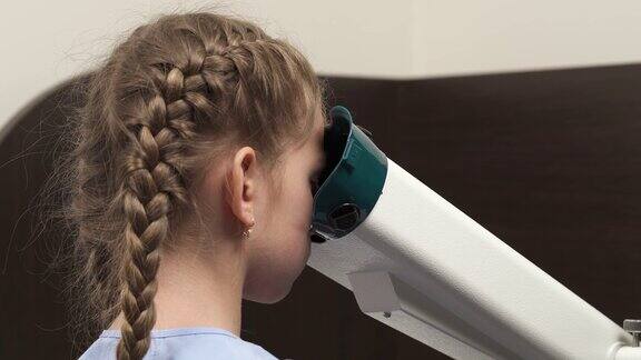 小女孩在眼科诊所做视力检查专业眼科设备使用视力测试