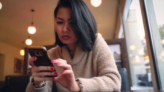 紧张的亚洲女人用手机发短信