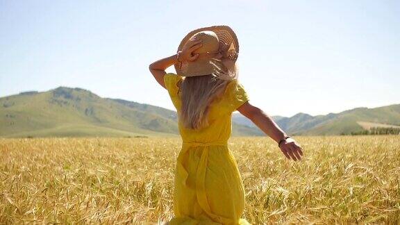 一个穿着黄色衣服留着长发的年轻女孩在麦田里奔跑慢动作