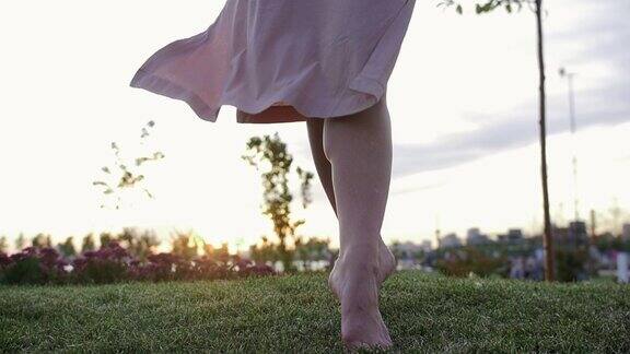 穿着米色衣服的女人光着脚慢镜头走在草地上