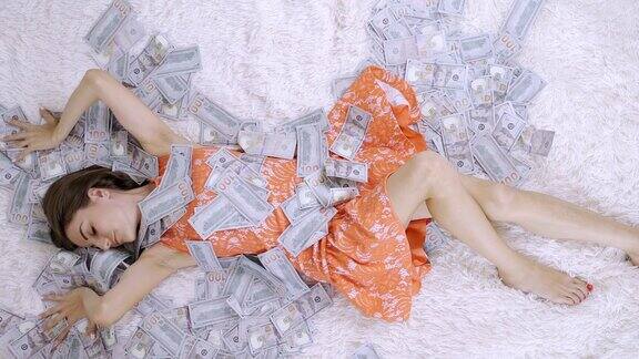 美丽的女孩享有巨大的财富一个女人躺在一张白色的床上堆着一堆钞票多少钱