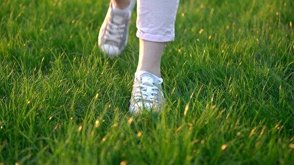 只看得见脚的女人走在绿草地上