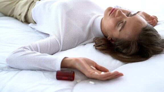 女子服用过量药物躺在木地板上药瓶开着过量用药和自杀