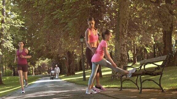 妈妈在公园里教女儿做伸展运动