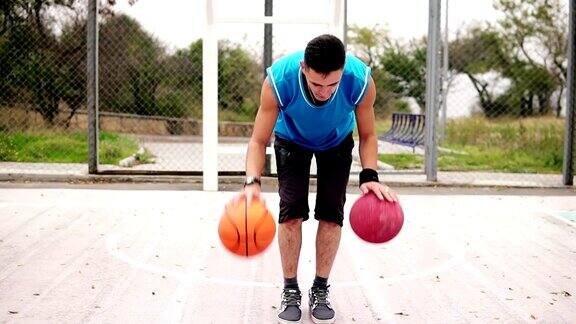 一个年轻人在街头球场练习篮球的特写镜头他正在同时玩两个球Slowmotion拍摄