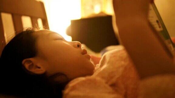 亚洲女孩晚上在床上看书生活理念