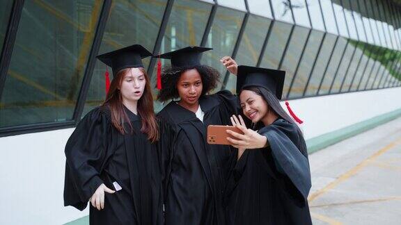 一群不同的十几岁的女孩用手机自拍与朋友在她的毕业日在一起