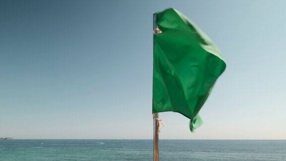 绿色的旗帜在蔚蓝的天空和地中海上飘扬