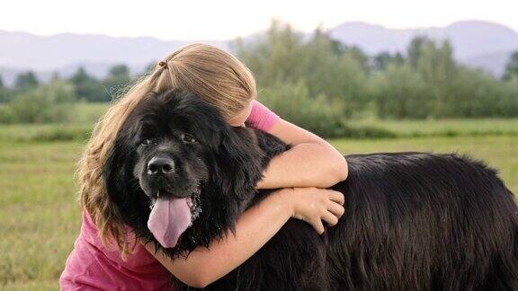 黑色纽芬兰狗被它的女主人拥抱