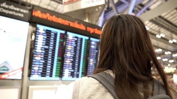 一名亚洲女子戴着防护面罩站在飞机前检查飞机