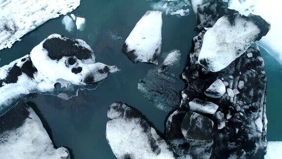 在冰岛南部海岸的Jokulsarlon泻湖上无人机在漂浮的冰山上空飞行