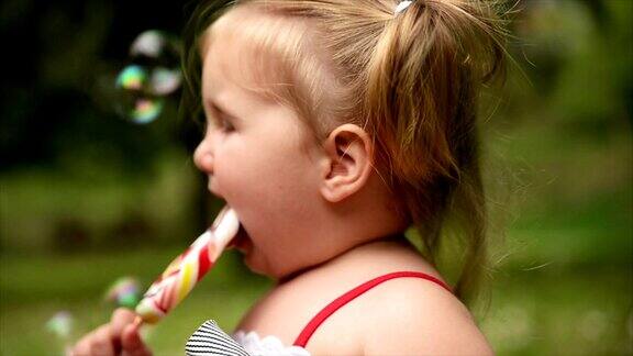 女孩吃棒棒糖缓慢的运动