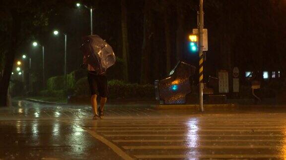 台风台湾期间行人撑着雨伞挣扎着穿过街道