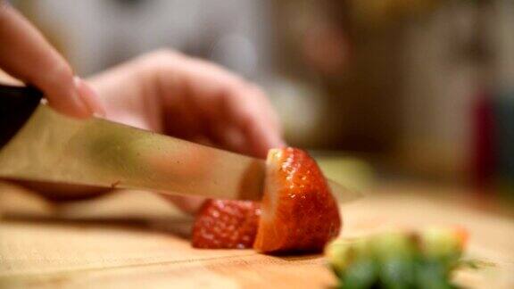女人正用刀在菜板上切草莓