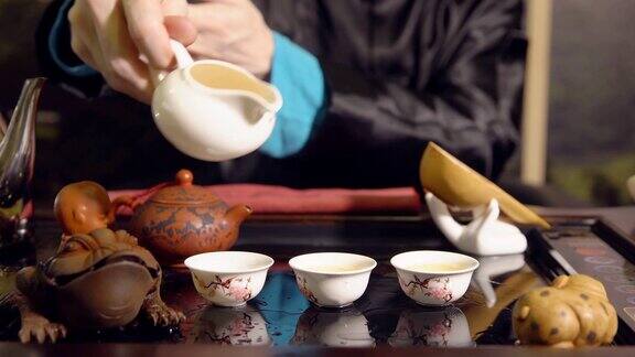 茶道师傅把茶倒在杯子上