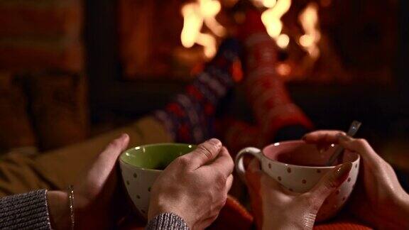 一对深情的情侣在壁炉边喝热茶