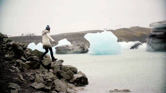 lopapeysa的年轻美女站在冰泻湖上游客独自探索冰岛的著名景点