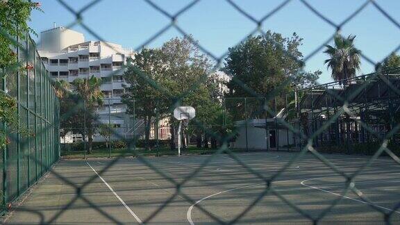 高高的金属围栏后面空荡荡的封闭篮球场