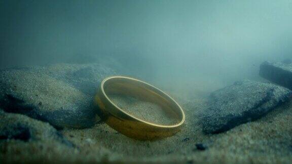 金戒指落在水下的岩石上