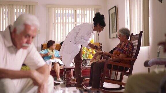 临终关怀医生给老年妇女测量血压