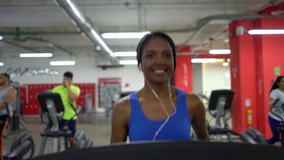 拉丁美洲黑人妇女在健身房跑步机上跑步