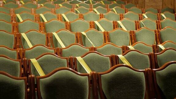 戏院或电影院大厅里的空椅子电影院大厅里的座位用胶带覆盖以保持社交距离一个空的电影院大厅椅子上覆盖着黄色胶带以符合卫生标准流行covid-19没有人