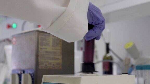 女研究员使用实验室摇床搅拌红葡萄溶液