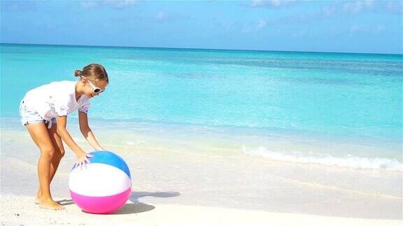 可爱的小女孩在沙滩上玩球