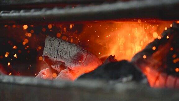 特写的一些木炭燃烧在烧烤在慢动作