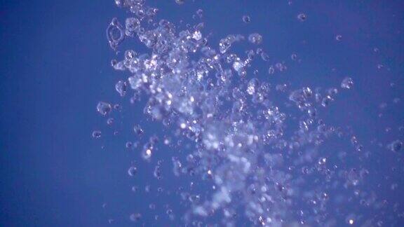 慢动作:蓝色背景上分散的水滴