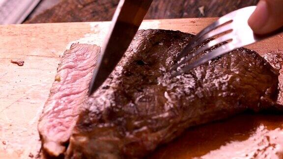 厨师在案板上用刀叉将西冷牛排切成片
