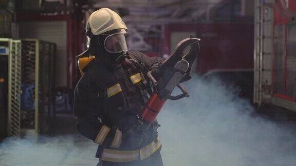 身穿全套装备、氧气面罩、电动液压切割工具的消防员肖像背景是烟雾和消防车姓名标签翻译为消防员和模特的姓
