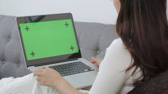 女人用笔记本电脑像视频电话和搜索信息绿色屏幕上有标记点