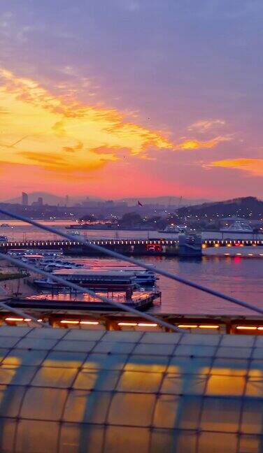 在美丽的夕阳下一列火车在桥上驶入现代火车站的航拍侧面-伊斯坦布尔乌卡帕尼地铁桥-垂直