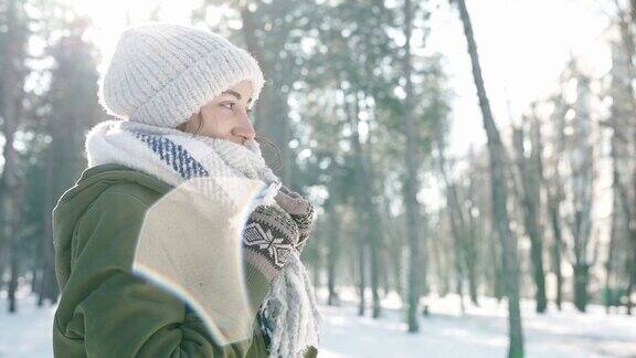 冬季肖像滑稽微笑的女人在羊毛帽子和长温暖的围巾在下雪的冬天公园在寒冷的晴天冬天快乐玩得开心