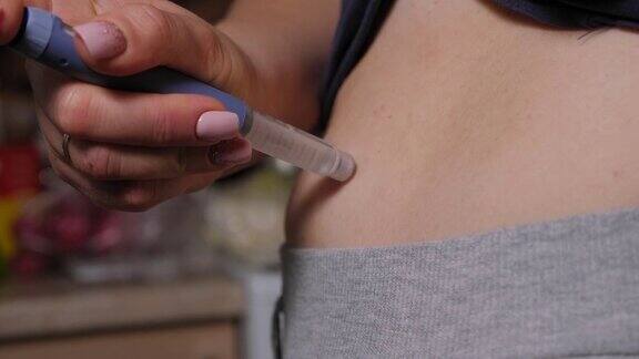 糖尿病妇女正在用胰岛素笔在胃里注射胰岛素