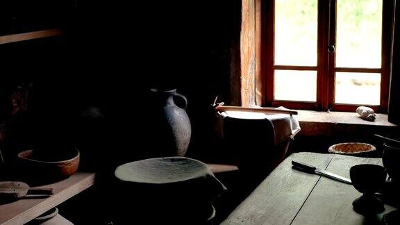 在黄昏的光线下木制房子的厨房内部与古董陶器