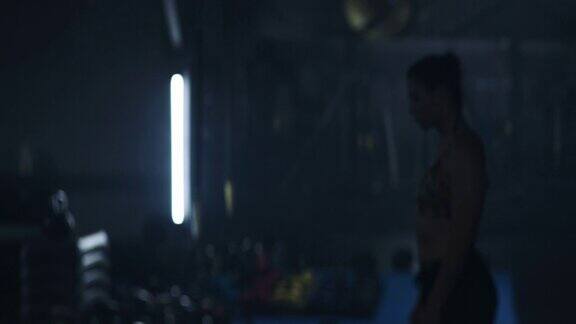 MMA的女战士在黑暗的健身房拍照