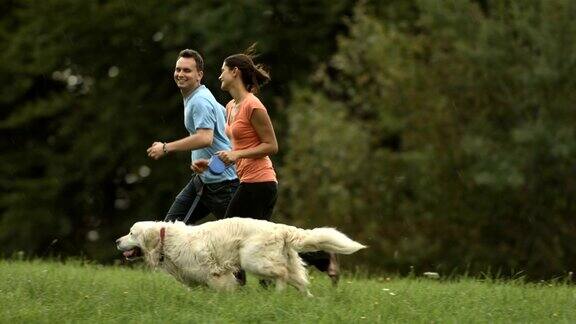 爱的夫妇和他们的狗跑步