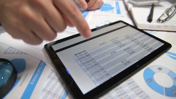 商人用平板电脑工作计算阅读和写作报告办公室职员桌子特写企业财务会计概念