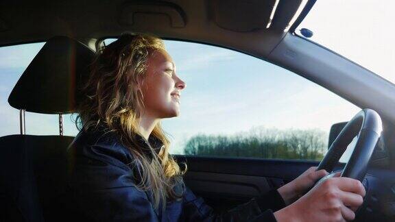 一位年轻女子开着一辆汽车在乡间小路上行驶汽车在不平坦的柏油路面上摇晃着