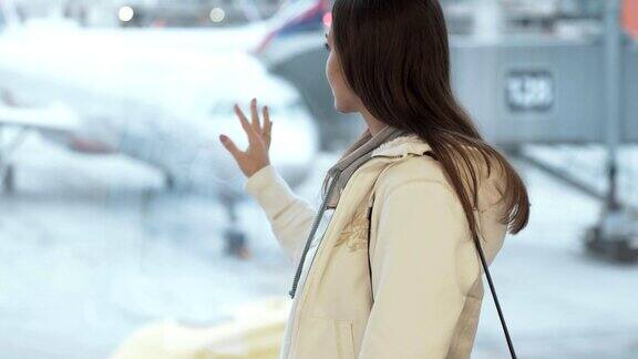 侧面的漂亮女人看着窗外的机场背景的飞机