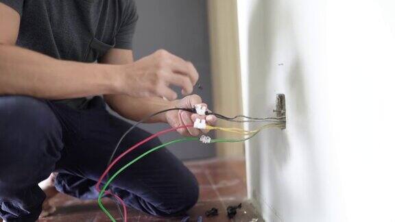 关闭了亚洲华人男性电工连接插座到电线将电线安装到插头上