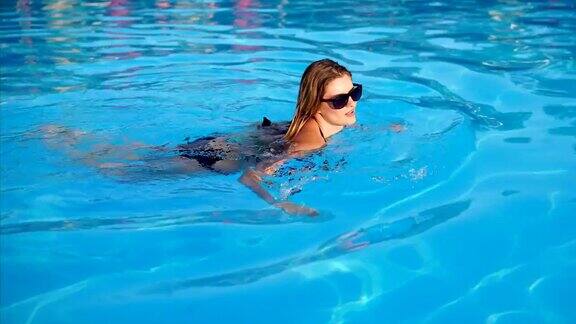 女人独自在游泳池里安静地游泳