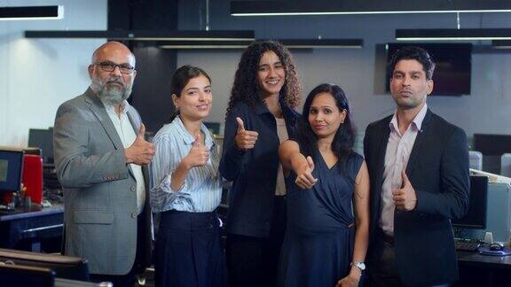 一群雄心勃勃的印度男女混合企业员工竖起大拇指