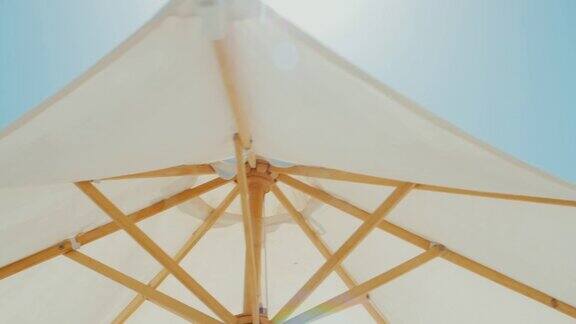白色雨伞映衬着蓝色的天空在海滩度假胜地替身拍摄