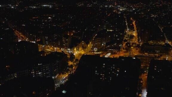 城市夜景航拍在城市街区的照明街道和十字路口交通量低西班牙巴塞罗那