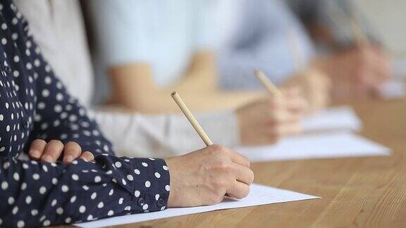 大学生坐在课桌前写考试概念特写