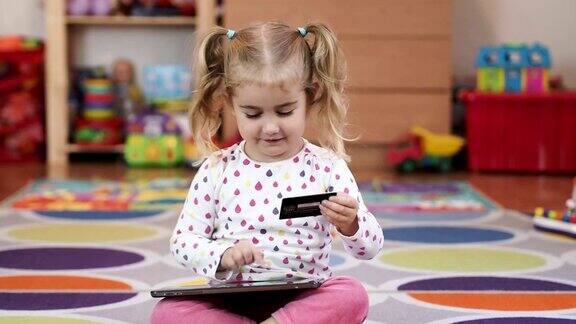 小女孩用平板电脑网上银行用信用卡网上购物居家生活方式