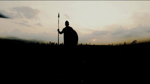 在干燥的田野里战士手持长矛摆姿势的剪影